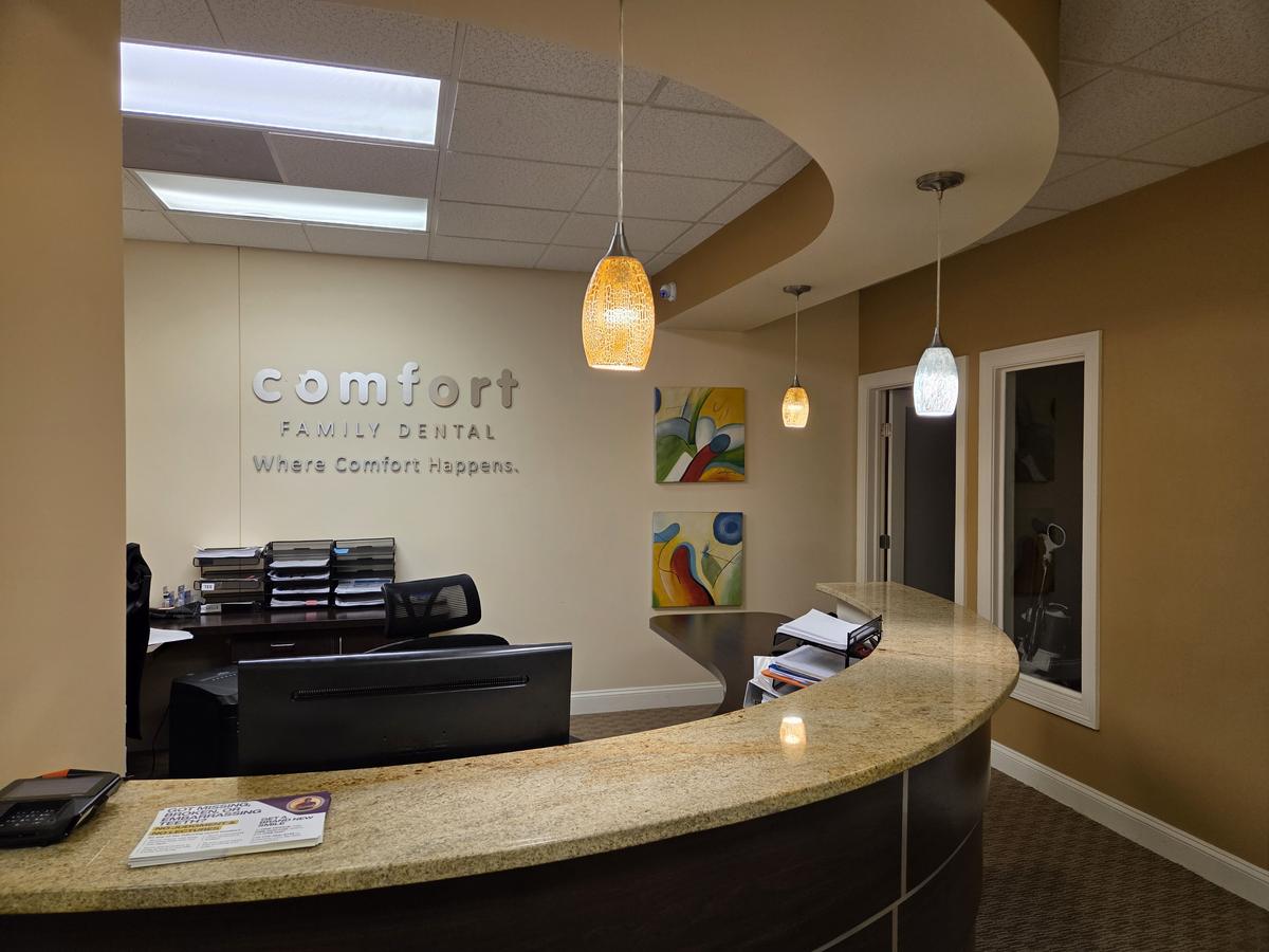 Comfort Family Dental reception desk with the practice name and Where Comfort Happens tagline on the wall
